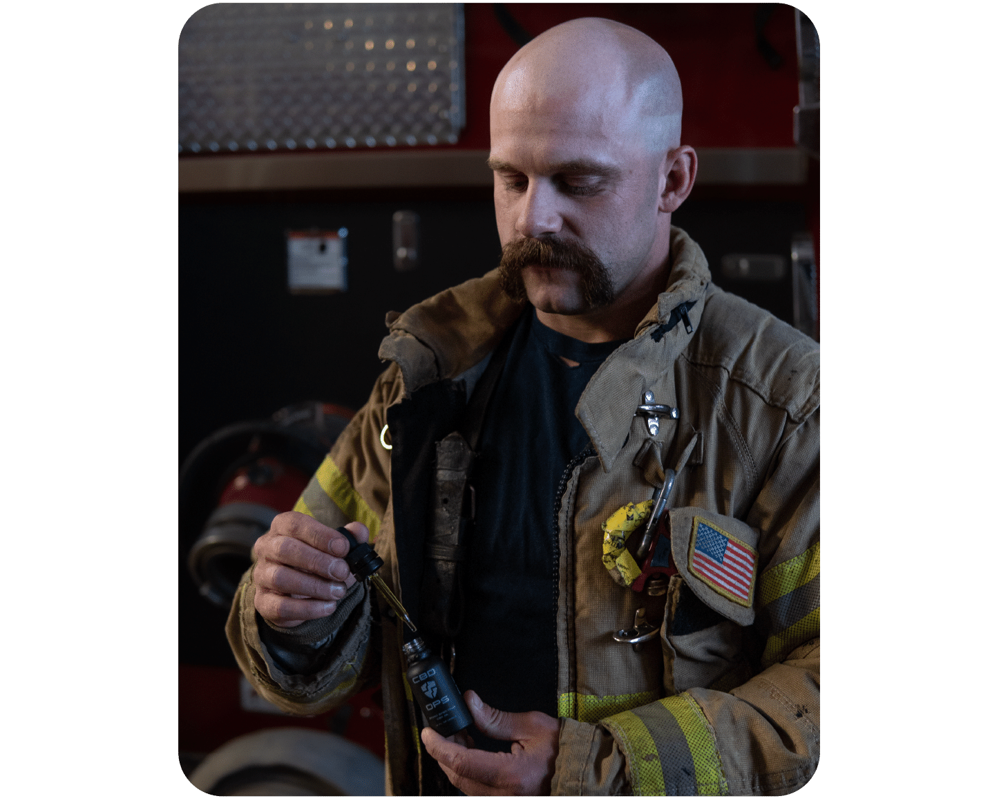 Male firefighter reaping the benefits of CBD for first responders by applying CBD tincture oil.