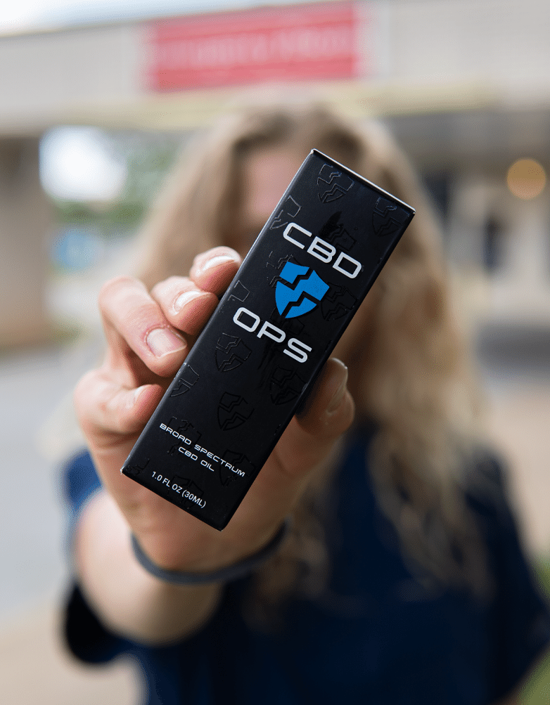  Nurse holding up a CBD product that can help relieve stress and improve well being for nurses. 