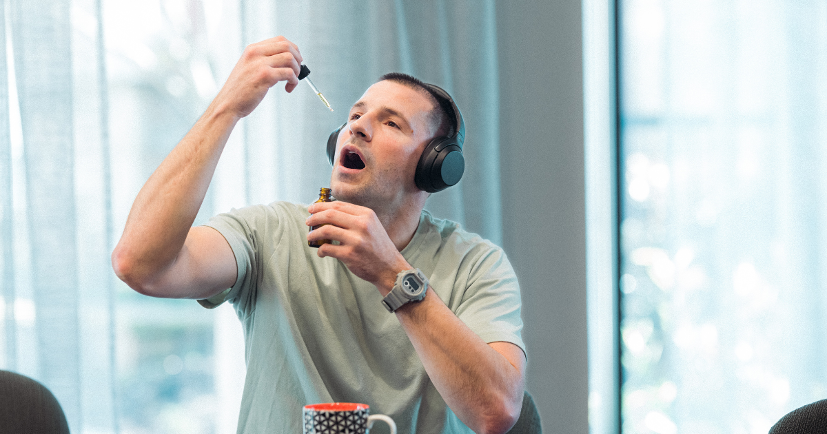 First responder taking cbd for muscle recovery with a dropper.